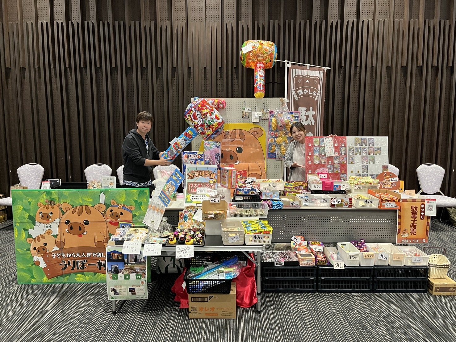 スタッフと駄菓子が並ぶイベント会場の売り場